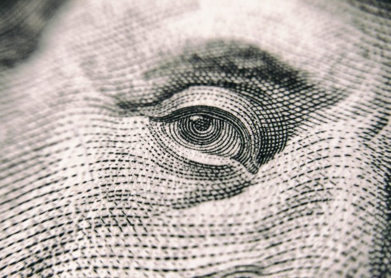 A close up of Benjamin Franklin's eye on a US dollar bill