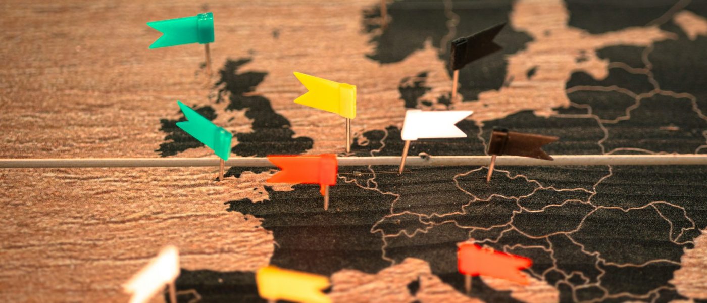 Flag pins on a wooden board map of Europe - UNSPLASH Flag pins on a wooden board map of Europe