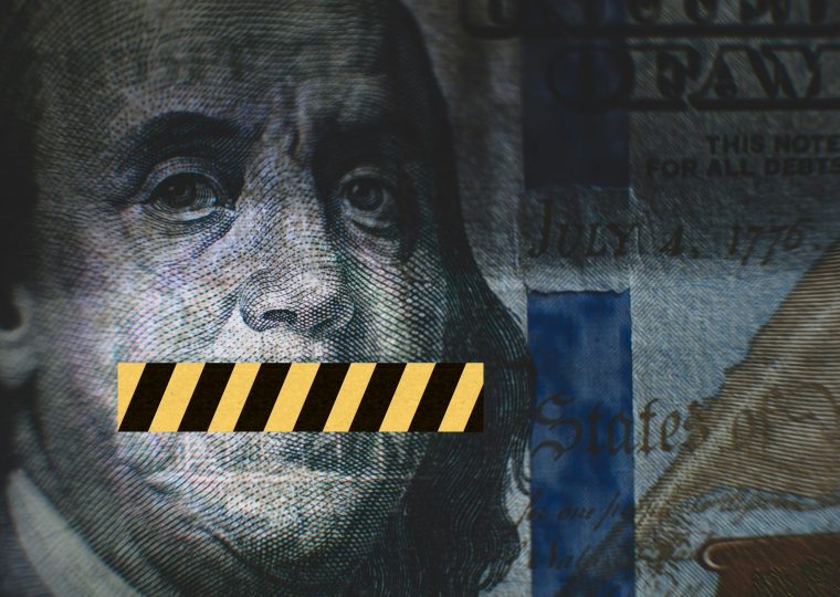 A close of Benjamin Franklin on a US dollar bill with a yellow and black strip covering his mouth