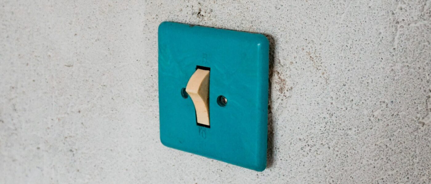 Blue light switch on a white wall - UNSPLAH Blue light switch on a white wall