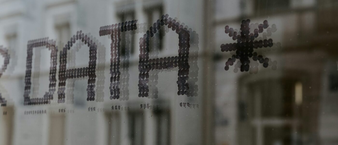 A close of up the word Data on a window reflecting a building - UNSPLASH A close of up the word Data on a window reflecting a building