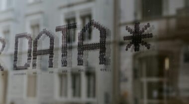 A close of up the word Data on a window reflecting a building - UNSPLASH A close of up the word Data on a window reflecting a building