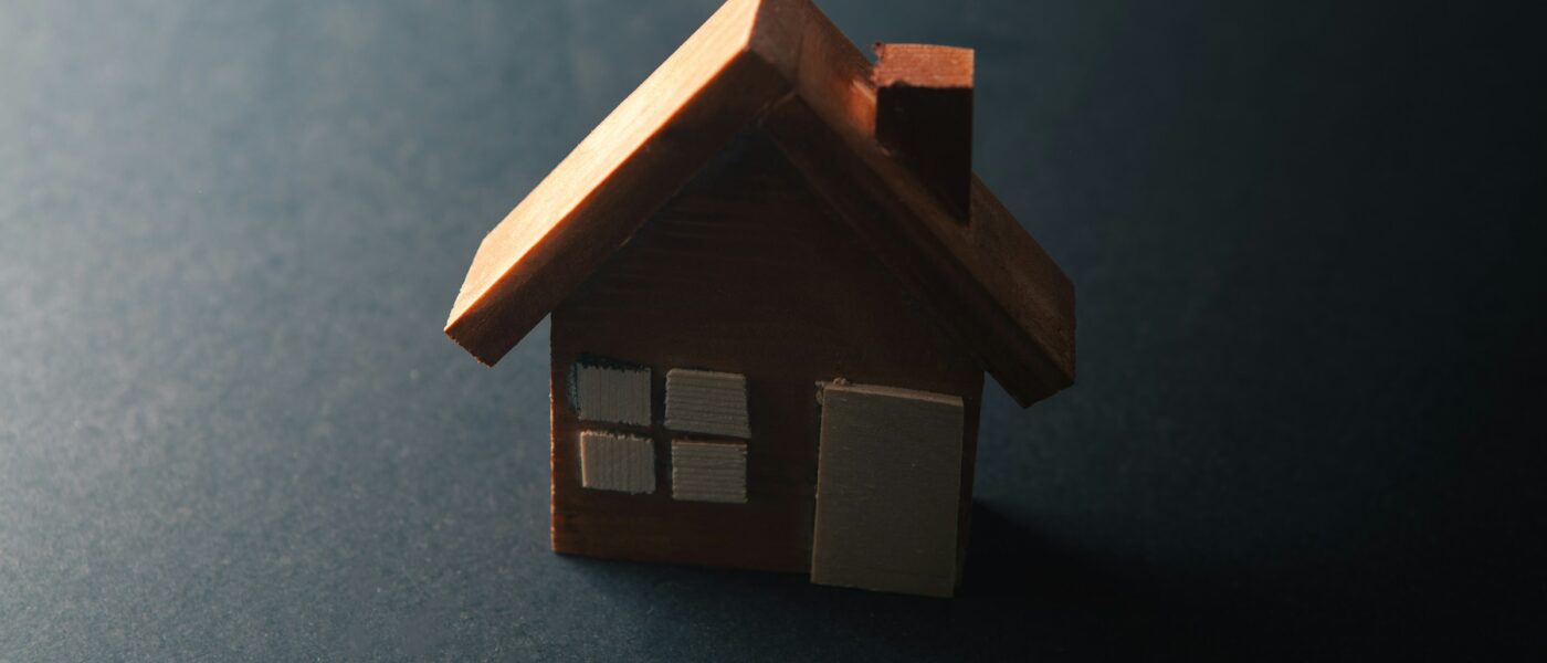 A wooden toy house in a shadow - UNSPLASH A wooden toy house in a shadow