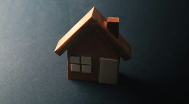 A wooden toy house in a shadow - UNSPLASH A wooden toy house in a shadow