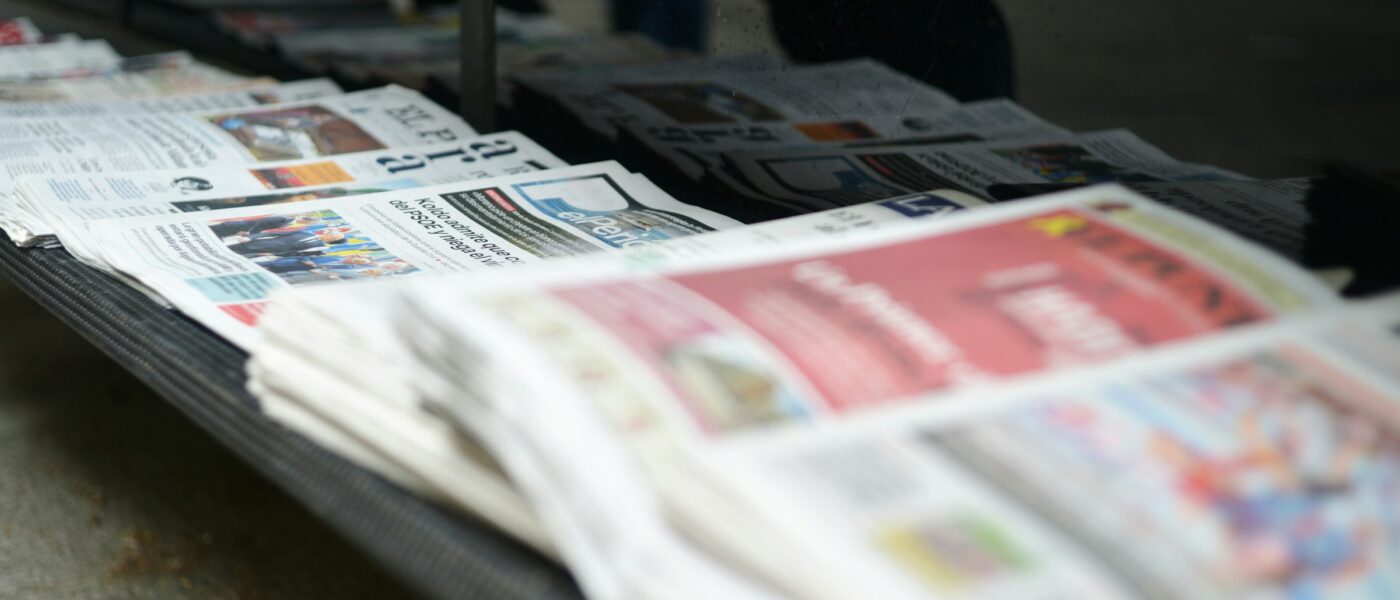 A row of newspapers on a shelf - UNSPLASH A row of newspapers on a shelf