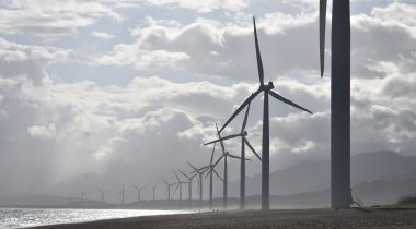 A line of wind turbines along a cost