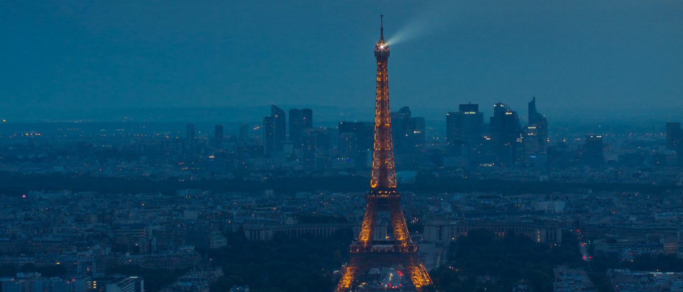Eiffel Tower spotlight against a stormy evening sky