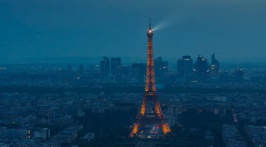 Eiffel Tower spotlight against a stormy evening sky
