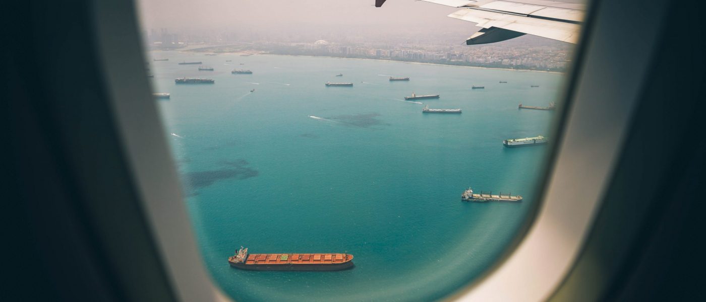 View of port and cargo ships from airplane window