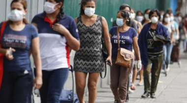 Women queuing in a line wearing face masks